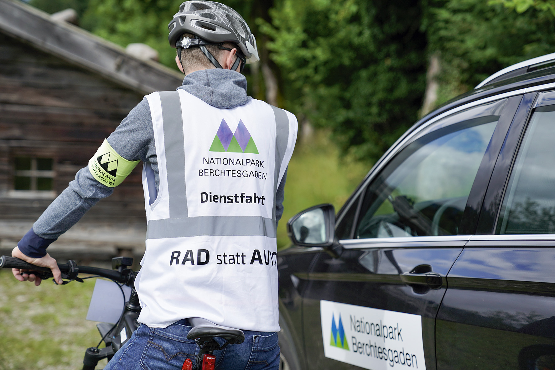 Pressebild: Wo möglich gilt im Nationalpark Berchtesgaden ab sofort: „Rad statt Auto“. Nationalpark-Mitarbeitende, die bei ihrem Dienst im Gelände zu Fuß, mit dem Rad oder per PKW unterwegs sind, sind ab sofort noch besser als Nationalparkpersonal zu erkennen. Dafür sorgt eine eindeutige PKW-Beschilderung sowie die neue „Radl-Weste“ bei Dienstfahrten. Saisonale Mitarbeiter und Praktikanten, die keine offizielle Dienstkleidung haben, tragen beim Dienst im Gelände hellgelbe Armbinden mit Nationalparklogo.