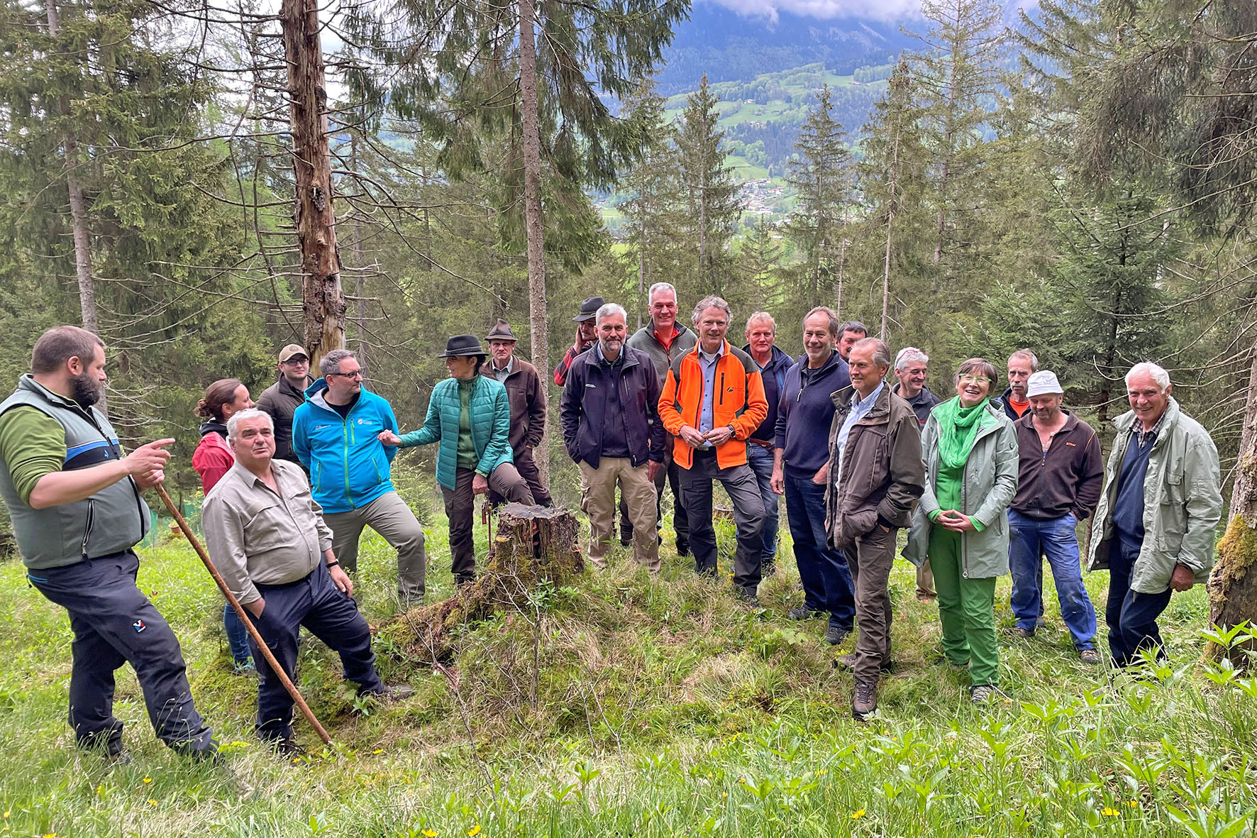 Pressebild: Diskussion der Gruppe an einem stark aufgelichteten Schutzwald in Siedlungsnähe am Fuß des Grünsteins.